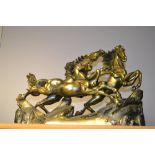 A bronzed resin model of three feral horses, cantering on a rocky ground, 30cm high