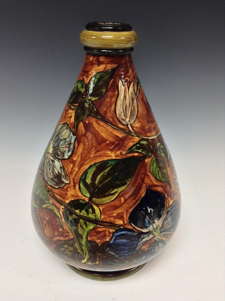 A Doulton Lambeth Faience ovoid vase, painted underglaze with iris flowers on a brown ground,