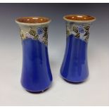 A near pair of Royal Doulton slender inverted baluster vases,
