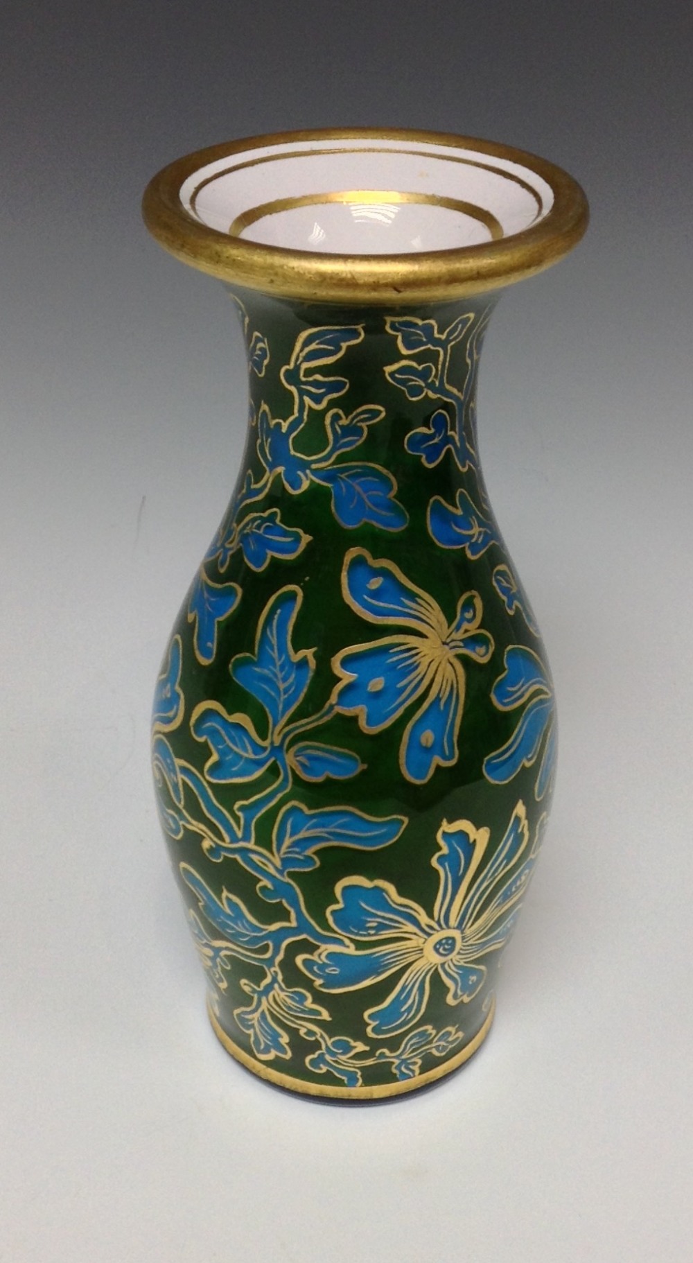 A Bohemian blue glass baluster vase, cased with green, picked out with gilt foliage,