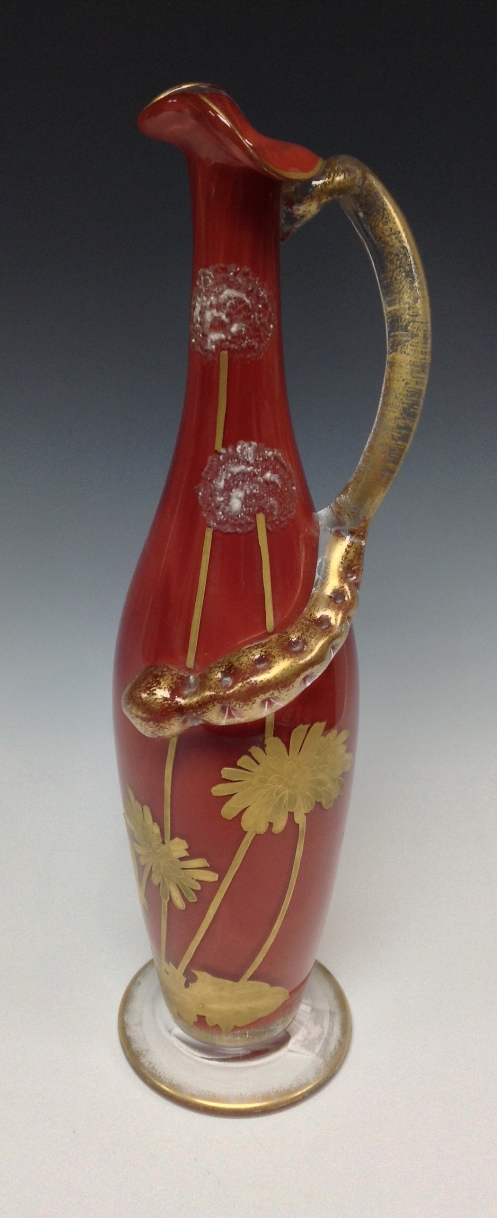A sang-de-boeuf ewer glass vase, decorated with enamel and gilt flowers, glass snake handle, 22cm