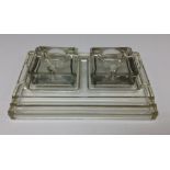 An Art Deco Ace press moulded clear glass inkwell and stand, two pen trays,