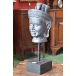A resin bust of a Thai deity in ornate head dress, painted in black, square block base,