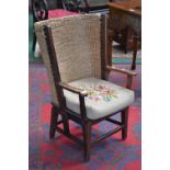 An oak Orkney chair, wrap around raffia back, tapestried stuffed over seat,