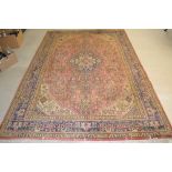A Tabriz carpet, woven in shades of red and blue on a cream ground, 2.9 meters x 1.