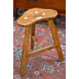 A rustic shaped topped milking stool,