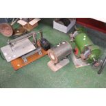 An electric bench grinder with brush/polishing attachment and wheels; an electric bench top fretsaw;