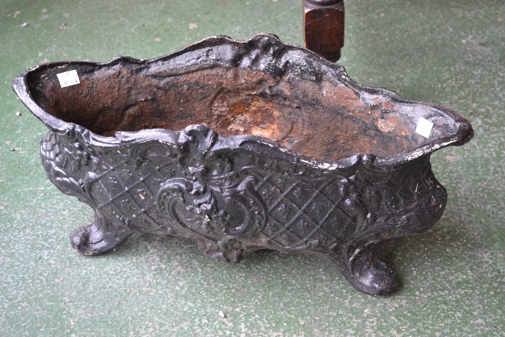 A Victorian Rococo style cast iron lozenge shaped planter, supported on four scroll feet,