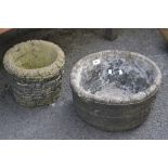 A large reconstituted stone plant pot; another,