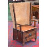 A pine Orkney chair, wrap around raffia back, open arms with scrolling terminals,