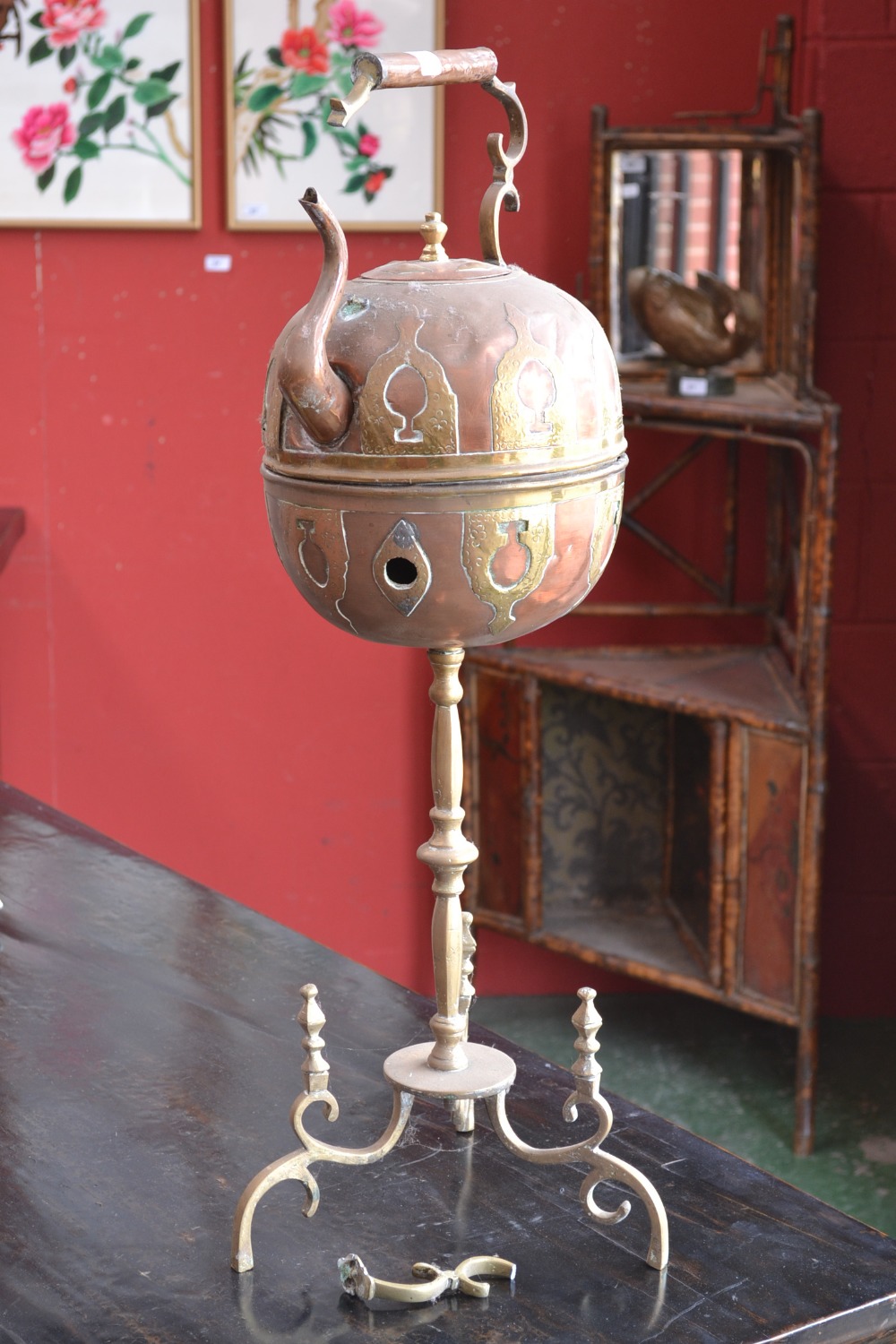 A brass and copper kettle on stand