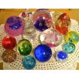 Paperweights - a Caithness blue moon crystal; a CHG ruby red and cut glass globe; a pebble;