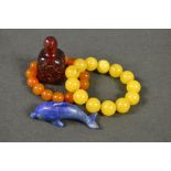 An amber bracelet; another, similar; a chinese snuff bottle,