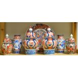 A pair of late 19th century Japanese Imari palette inverted baluster jars and covers;