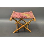 A 19th century folding book stand, tapestry top decorated with two birds, gilt bamboo effect legs,