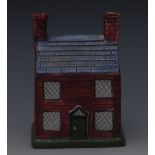 A Scottish pottery cottage money box, with green front door, red bricks, light blue roof, 12.5cm