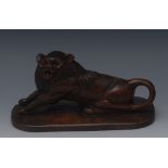 A 19th century naive folk art carving, of a lion, seated, with front paws outstretched,