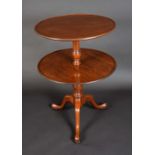 A George III mahogany two tier circular dumb waiter, dished plateaux,