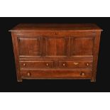 An early 18th century oak mule chest, rectangular plank top above three fielded panels,