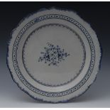 An early 19th century shaped circular charger, decorated in blue with stylised foliage,