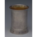 A George III silver flared cylindrical beaker, gilt interior. skirted base, 9.