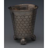 A 19th century German silver bucket shaped beaker, chased with rows of scales, ball feet,