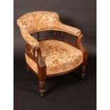 A Victorian mahogany club chair, curved upholstered back with spindle gallery, stuffed-over seat,