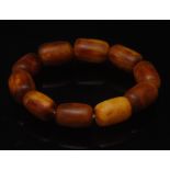 A Butterscotch amber coloured bead bracelet, composed of ten barrel form beads,