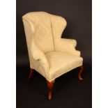 A George II design mahogany wing back armchair, stuffed over damask upholstery, cabriole legs,