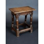 An early 18th century oak joint stool, rectangular top with moulded edge, shaped apron,