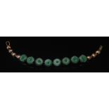A Jade articulated bracelet, eight circular shield panels,