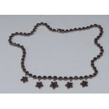 An Edwardian garnet fringe necklace, five independently mounted five point flowerhead drop fringe,