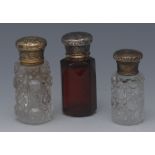 A Victorian ruby glass scent bottle, silver coloured metal cover engraved with scrolling foliage,
