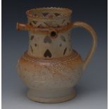 A 19th century salt glazed stoneware puzzle jug, in relief with huntsman horses and hounds at kill,