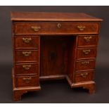 A late George II/George III walnut knee hole desk, the top outlined with feathered crossbanding,