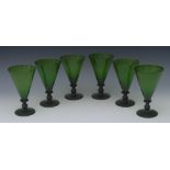 A set of six conical green glass drinking glasses, tall funnel shaped bowls, knopped stems,