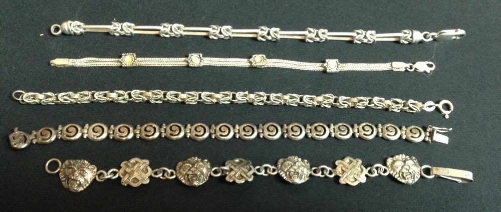 A silver lion mask and Celtic knot alternating seven panel bracelet;  another,