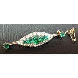 A diamond and green stone brooch,