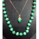 A malachite and paste pendant, the malachite egg pendant mounted in a yellow metal tri-claw drop,