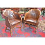 A pair of leather club chairs, arched curving back, padded seat,