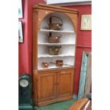 A large pine corner cabinet, canted fluted angles, three shaped shelves to top,