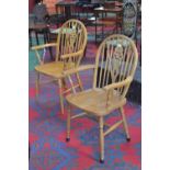 A pair of contemporary spindle back beech wood chairs, wheel back splat, open arms,