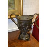 A large bronze two handled urn, cast in relief with Bacchus and attendants,.