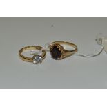 A lady's 9ct gold and garnet dress ring; a lady's 9ct gold dress ring,