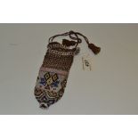 A Victorian  beadwork drawstring  purse, embroidered with polychrome beads with geometrical motif,