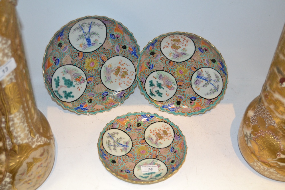 A set of three graduated Japanese shaped circular plates, painted with roundels,