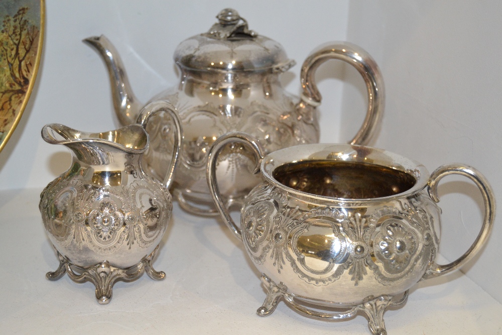 A Victorian silver-plated three-piece tea set, comprising melon-shaped teapot with ceramic ferrules,