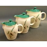 A set of three graduated Denby Greenwheat pattern hot water jugs and covers (3)