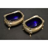 A pair of silver salts with blue glass liners,