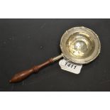 A George V silver orange strainer, turned wooden handle, Thomas Bradbury and Sons,